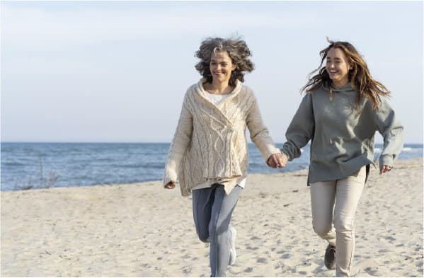 Mon and daughter happy running in the sand