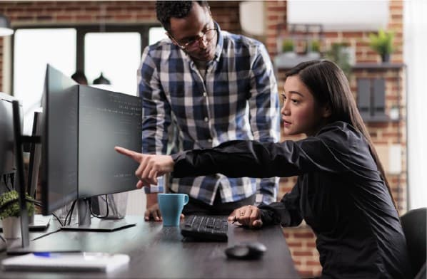 Women pointing to screen while talking to men