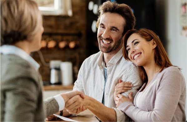 Happy couple giving handshake to women