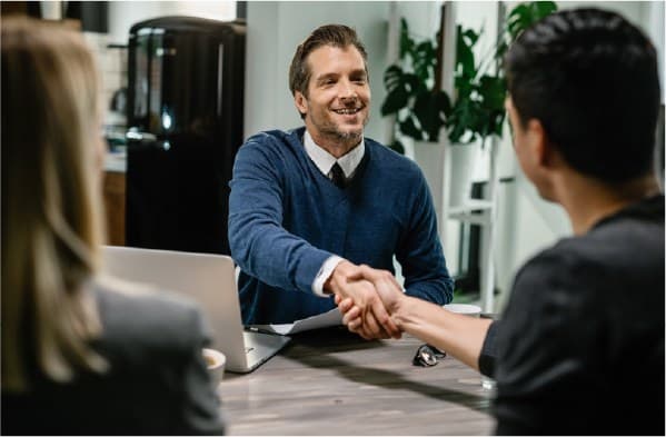 Happy men giving hand shake to another men